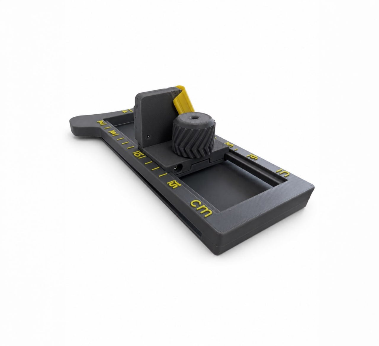 Angled side view of 3D printed hat brim cutter with adjustable guide, cutting blade, and centimeter and inch measuring scales