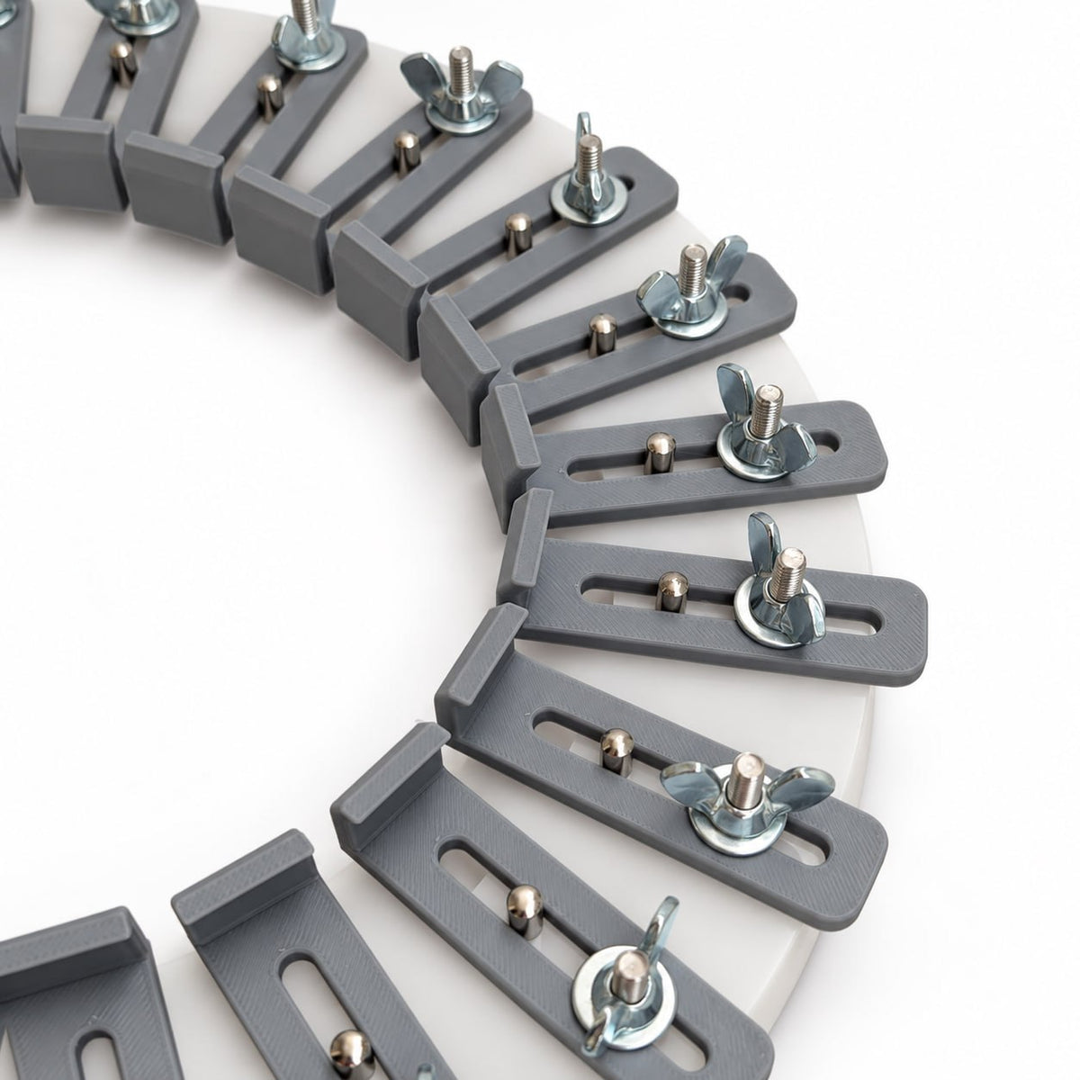 Close angled view of the acrylic hat conformateur adjustment system with movable gray fingers and stainless steel wing nuts for following and locking a customer’s head shape.